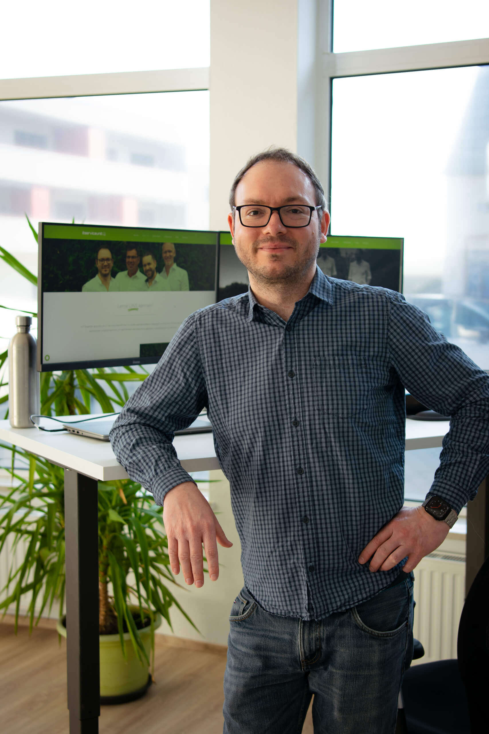 Michael Kapfer lehnt sich an einen höhenverstellbaren Schreibtisch